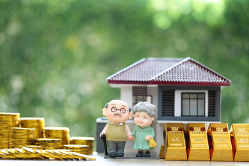 Mutual fund,Love couple senior on gold coin money and gold bar with model house on natural green background, Save money for prepare in future and pension retirement concept