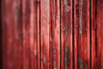 old red barn wood panel red paint texture that is flaking off low depth of field