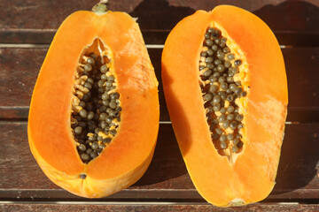 ripe papaya fruit in a cut on a wooden background.