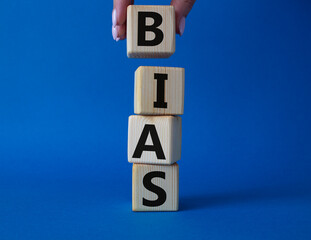 Bias symbol. Concept word Bias on wooden cubes. Businessman hand. Beautiful blue background. Business and Bias concept. Copy space.