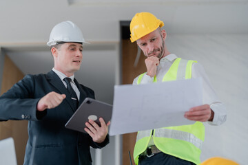 multi ethnic engineer brainstorming and measuring for cost estimating on blueprint and floor plan drawings about design architectural and engineering for houses and buildings