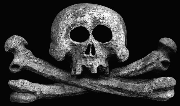 An ancient stone statuue of human skull as symbol of death and horror on bkack background.