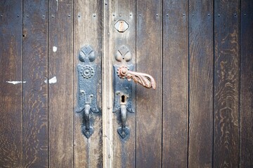 Vintage door handles. Old wooden front door with antique handle.