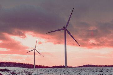 windmills in a snowy field at sunset