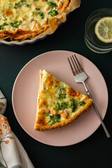 Homemade pie with red fish and broccoli, quiche with salmon and char, cheese and cream, portion of pie on a plate
