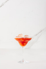 Alcoholic drink with tomato juice in a glass with ice close-up on a white background