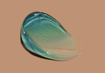 Cosmetic liquid cool blue cream smudge smear gel on beige peach background