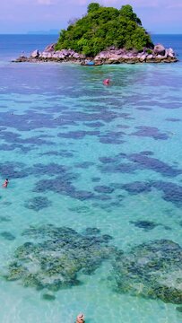 couple in kayak in the blue ocean of Koh Lipe Thailand padling to a small island in front of ko lipe island