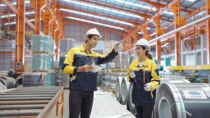 Male and female industrial engineers discuss and checking stock of steel metal at industry manufacturing factory