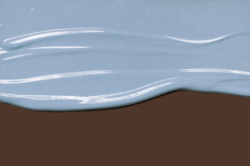 Blue cream mask glittering smudge on brown background