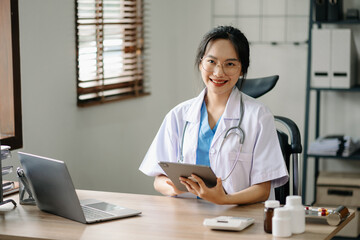 Asian smiling doctor or consultant sitting at a desk his neck looking at the camera.