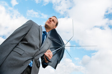 No coverage in sight for him. Shot of a businessman holding a broken umbrella.