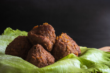 Fried cooked beef and pork meat balls on lettuce leafs closeup