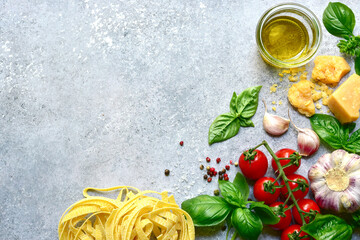 Traditional ingredients of italian cuisine : pasta, tomatoes,garlic,olive oil and parmesan cheese . Top view with copy space.