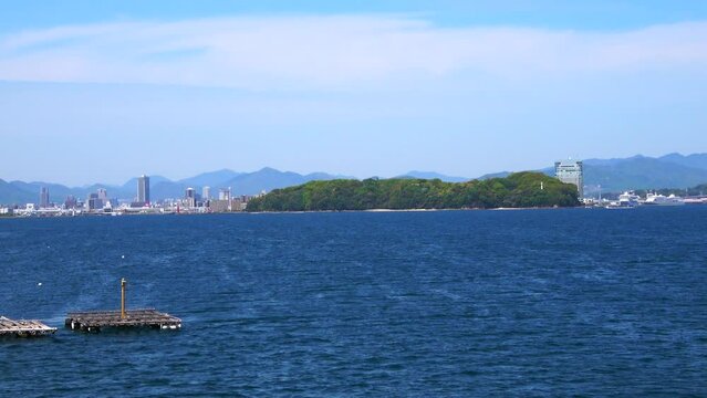 牡蠣養殖筏が浮かぶ瀬戸内海に面した広島市と宇品島の風景を船から移動撮影  4K  2023年4月23日