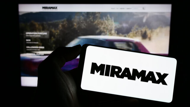 Stuttgart, Germany - 04-23-2023: Person holding mobile phone with logo of US television production company Miramax LLC on screen in front of web page. Focus on phone display.