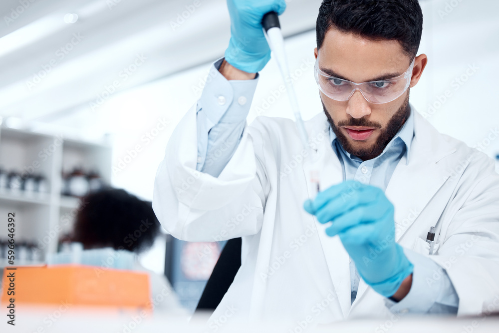 Poster one mixed race male scientist wearing safety goggles and a labcoat while conducting a medical resear