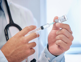 Keeping his patients safe. Shot of a dentist filling a needle with covid vaccine.