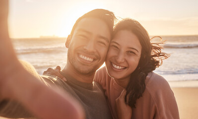 Portrait of a young diverse biracial couple taking a selfie at the beach and having fun outside. Portrait of a young diverse biracial couple taking a selfie at the beach and having fun outside. - Powered by Adobe