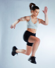 Time to level up. Full length shot of an attractive young female athlete posing in studio against a grey background.
