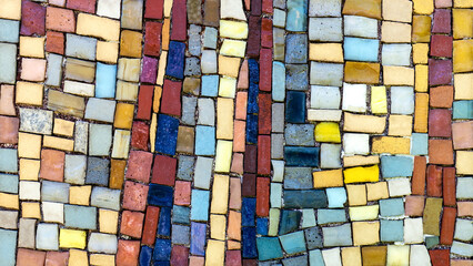 Detail von einem bunten, sehr alten Mosaik aus viereckigen Stückchen an einer verwitterten Wand