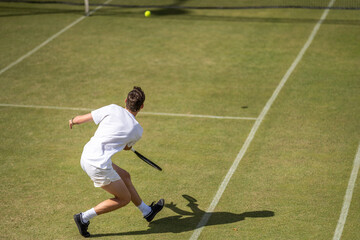 Amateur playing tennis at a tournament and match on grass in Europe 