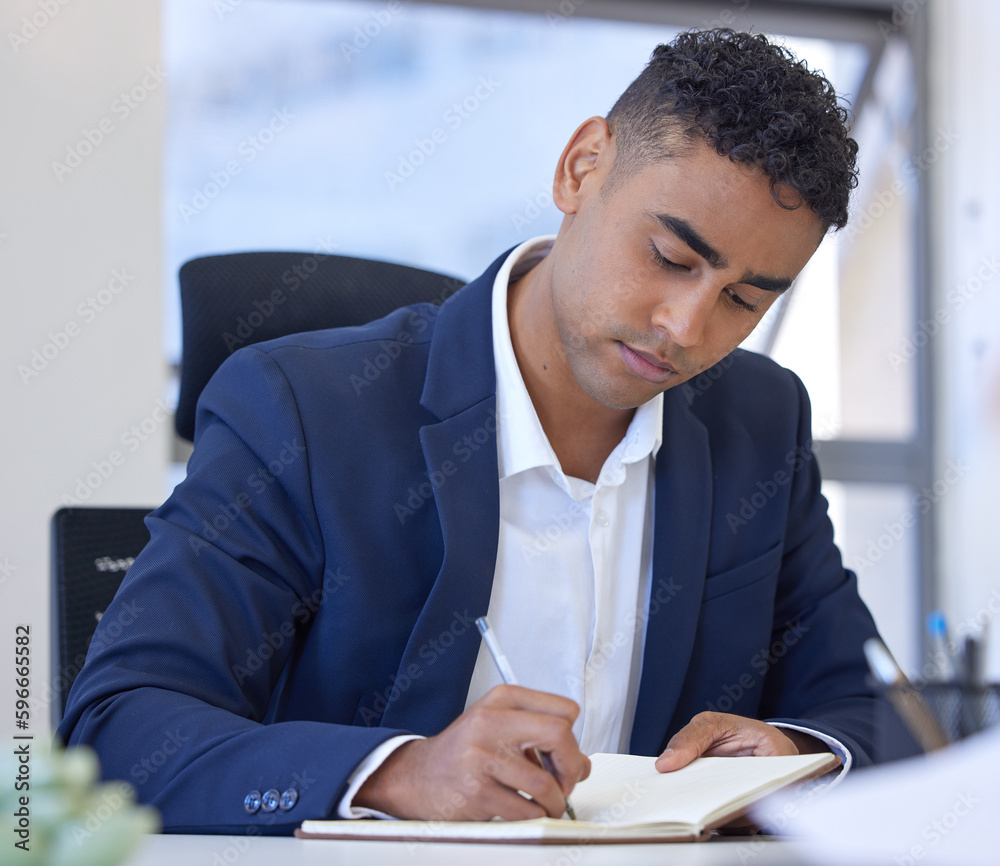 Poster ill jot that idea down for next time. shot of a young businessman writing notes while working in an 