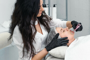 cosmetologist making mesotherapy injection with dermapen on face for rejuvenation. Anti-aging...