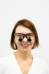 Portrait of a female dentist in binocular glasses.