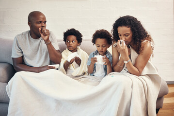 African american family of four feeling sick and unwell with flu and cold while covered in a...