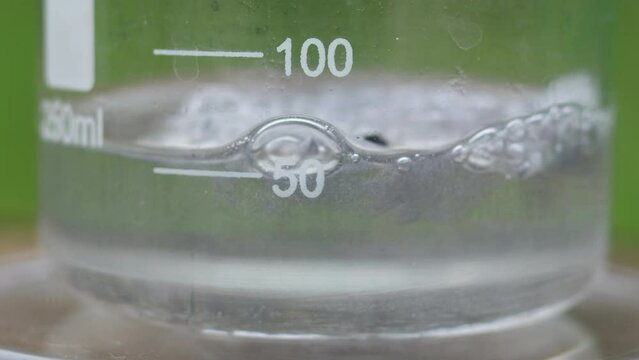 Violent chemical reaction of dissolving a large amount of active magnesium metal in dilute sulfuric acid in a beaker. A large amount of hydrogen gas is released.
