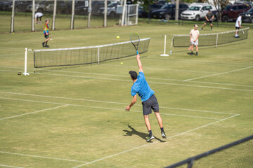 Amateur playing tennis at a tournament and match on grass in Europe 