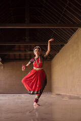 Indian Bharatanatyam dancer performing various steps wearing red saree.