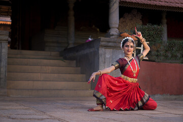 Indian Bharatanatyam dancer performing various steps wearing red saree.