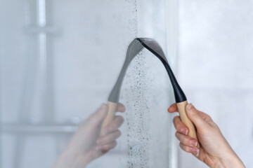 Glass squeegee erase drops and dirt on shower partition
