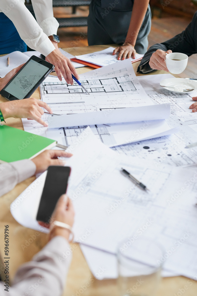 Poster Planning everything with precision and detail. Closeup shot of a group of architects working with blueprints in an office.