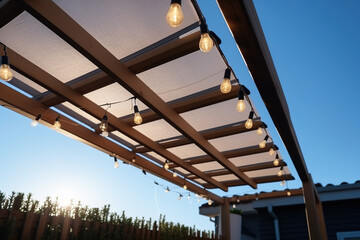 Canvas awning with metal frame and luminous garland of light bulbs against blue sunny sky. modern shading for house, created with Generative AI