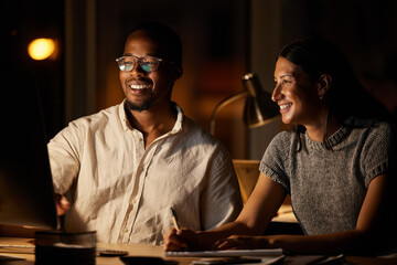 Just a few more edits and then well be done. Shot of two businesspeople working together on a computer in an office at night.