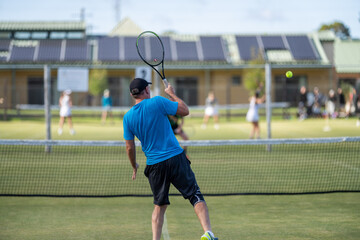 Amateur playing tennis at a tournament and match on grass in Europe 