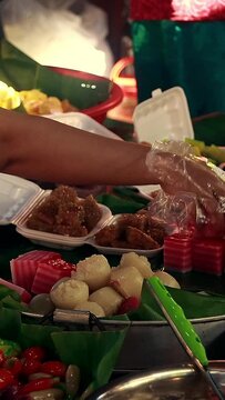 Seller arranging traditional authentic khmer desserts num chak kachan or layer cake and nom a kor or steamed rice cakes at the local market