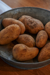 unwashed Potatoes in a Rustic Metal Bowl