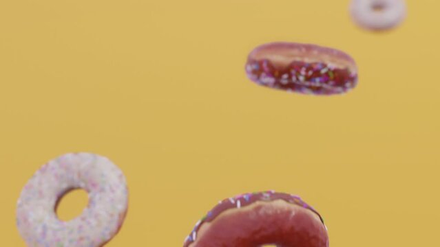 Donuts falling in slow motion. Yellow background. CInematic.