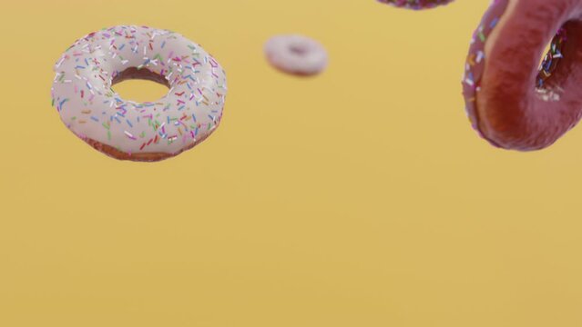 Donuts falling in slow motion. Yellow background. CInematic.