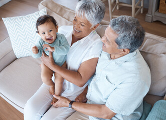 Obraz premium Such a sweet baby. Shot of grandparents bonding with their grandchild on a sofa at home.
