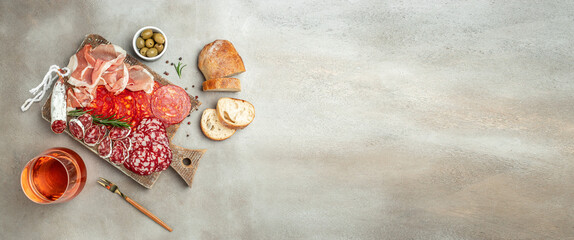 Meat platter appetizers on a light background. Long banner format. top view