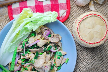 Sliced grilled beef salad, Isaan food in Thailand, local food in Thailand. Served with long beans and lettuce On a gray plate served in a Thai restaurant.
