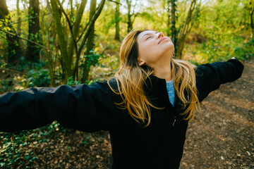 Attractive caucasian woman breathe fresh air , enjoying springtime on a sunset in natural parkland