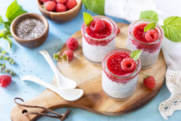 Healthy breakfast. Chia seed pudding with raspberry and jam or smoothies with chia seeds on a stone table.
