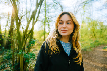 Naklejka premium Portrait of attractive caucasian woman hiking in a forest.