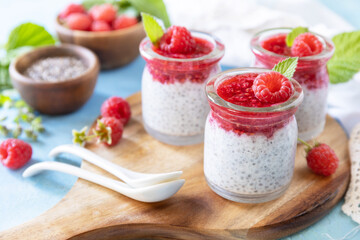 Chia seed pudding with raspberry and jam or smoothies with chia seeds on a stone table. Healthy breakfast.